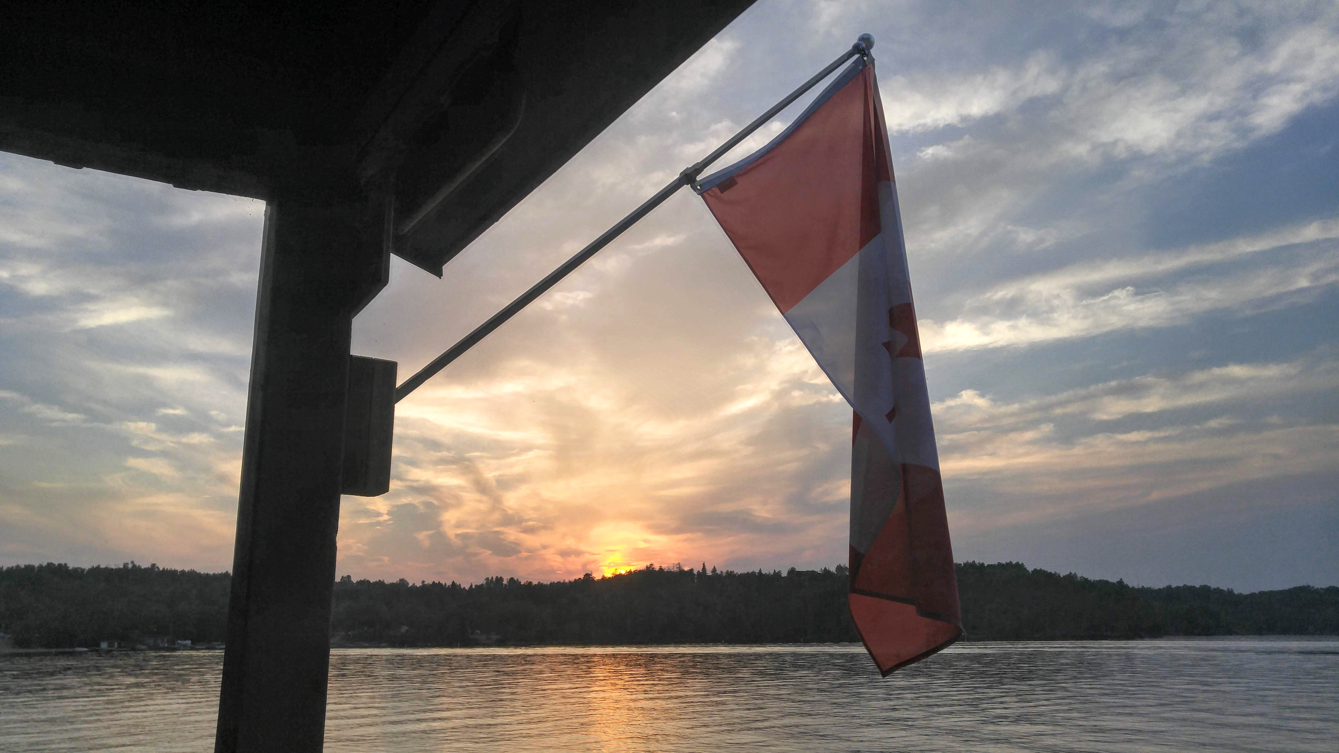 sunset over West Hawk Lake MB, with Canada flag in foreground